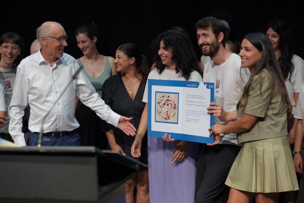 Urkundenübergabe des Friedenspreiskomitees vertreten durch Serpil Güclü (r.) und Eberhard Grötsch (l.) an Angela Nasimi und Baris Yüksel (Mitte) und das Team der WWgR. Foto: Thomas Rohloff. <br>